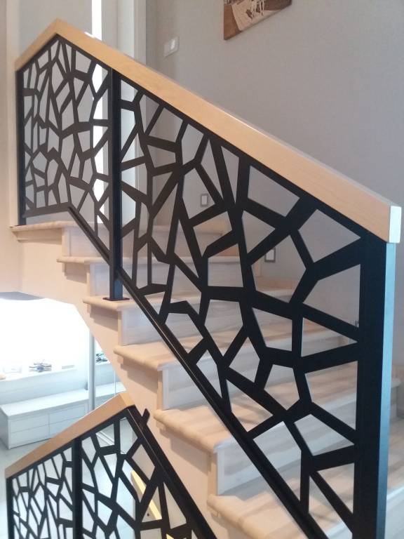 Panel ażurowy stalowy w balustradzie wewnętrznej z poręczą drewnianą.